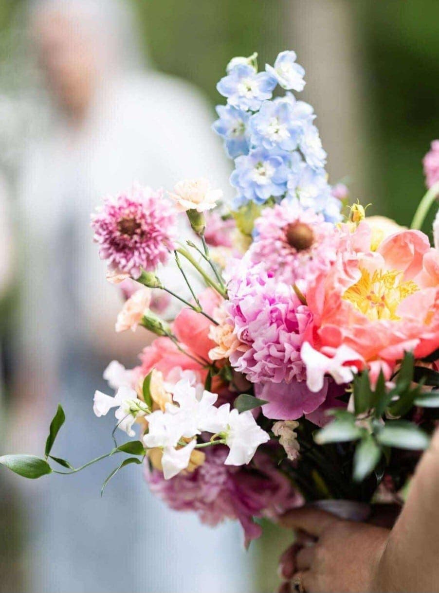 Luftig buket med pæoner, ridderspore og ærteblomster
